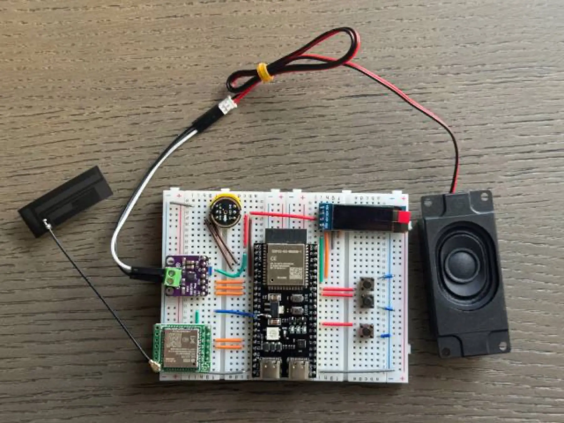 The author’s breadboard prototype illustrates the separate display, microphone and speaker arrangement. This is a different hardware example; use your board-specific pin map.