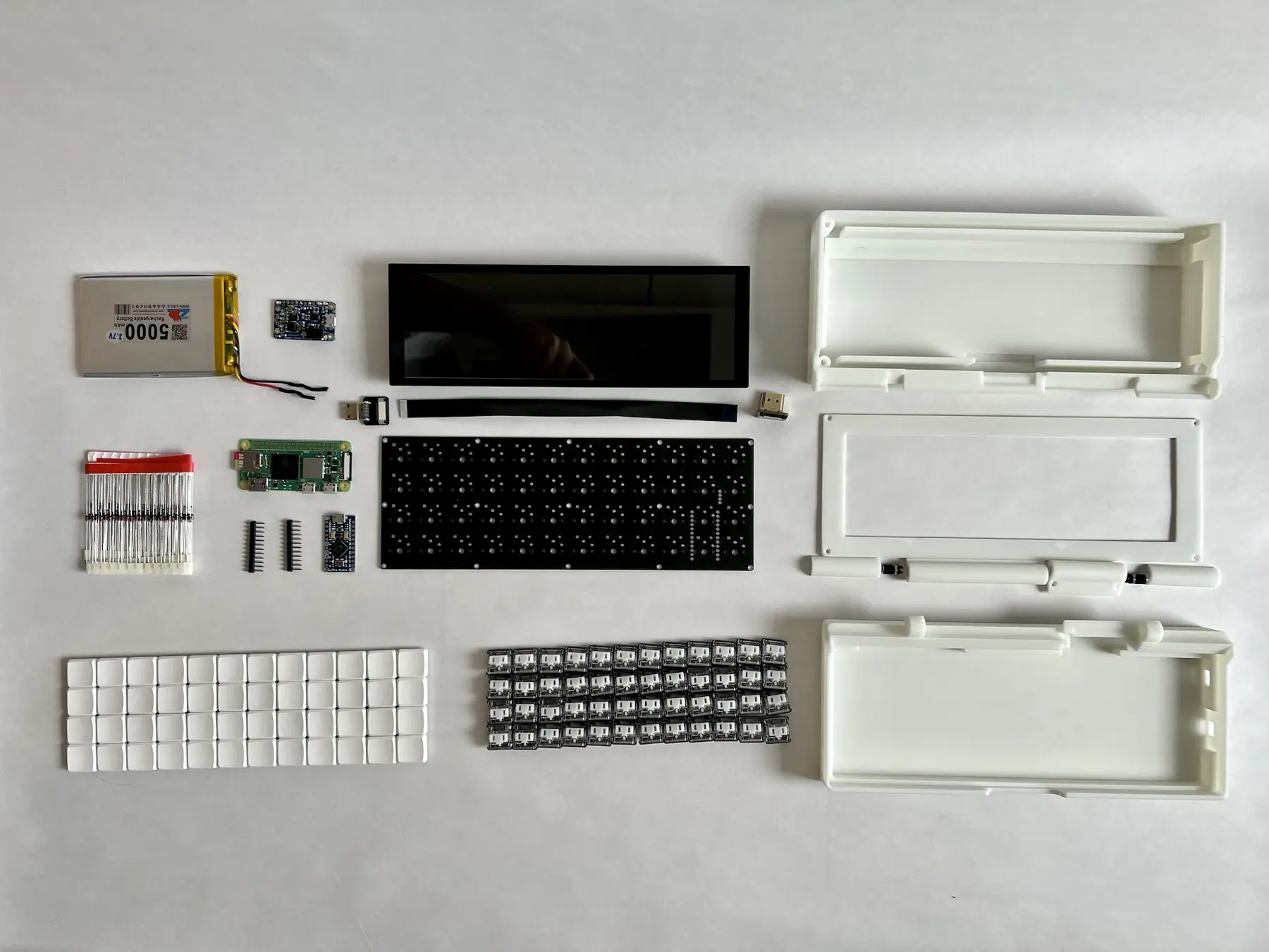 The original parts layout shows the small keyboard, display, compute board and enclosure pieces before assembly.