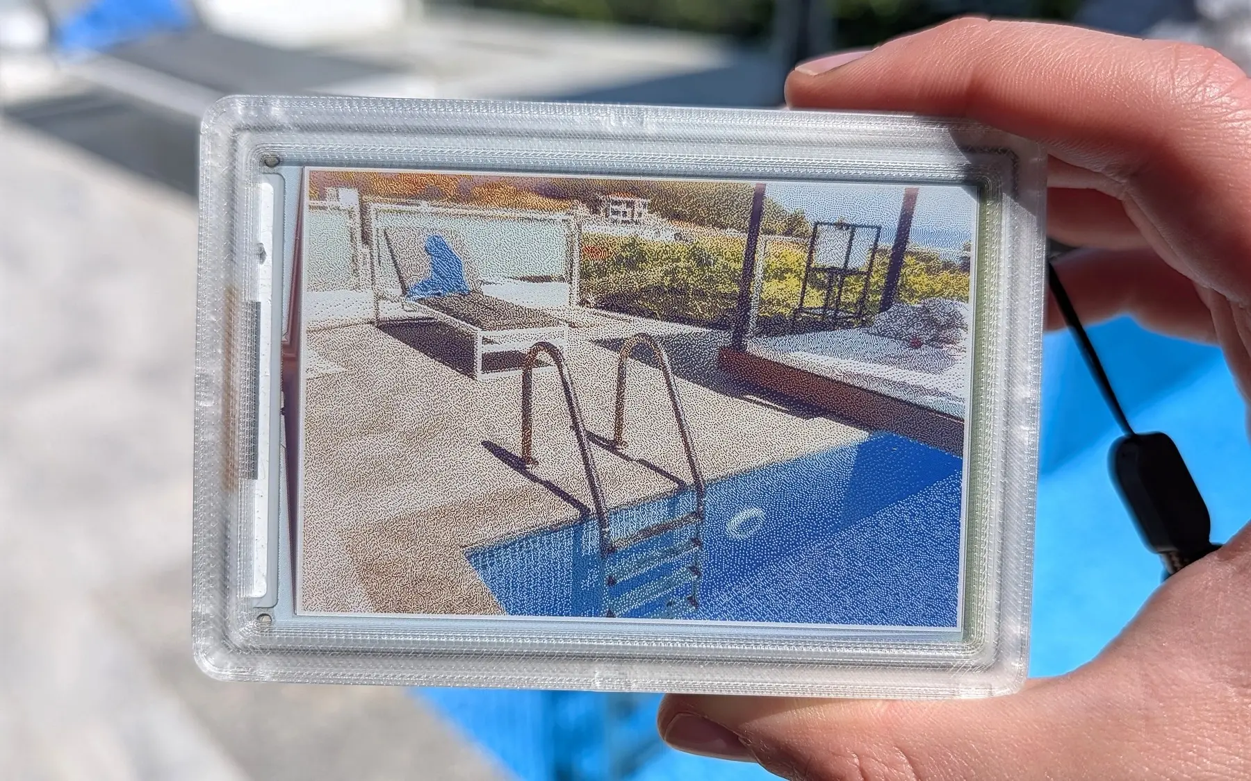 The original reFrame camera held beside its e-paper image.